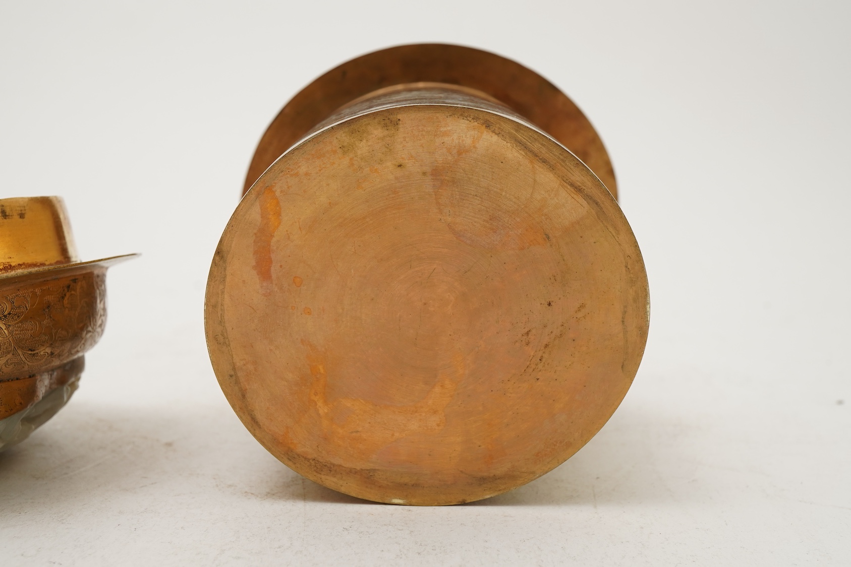 A Chinese pale celadon jade oval plaque, 17th/18th century, mounted on a late Qing gilt copper jar